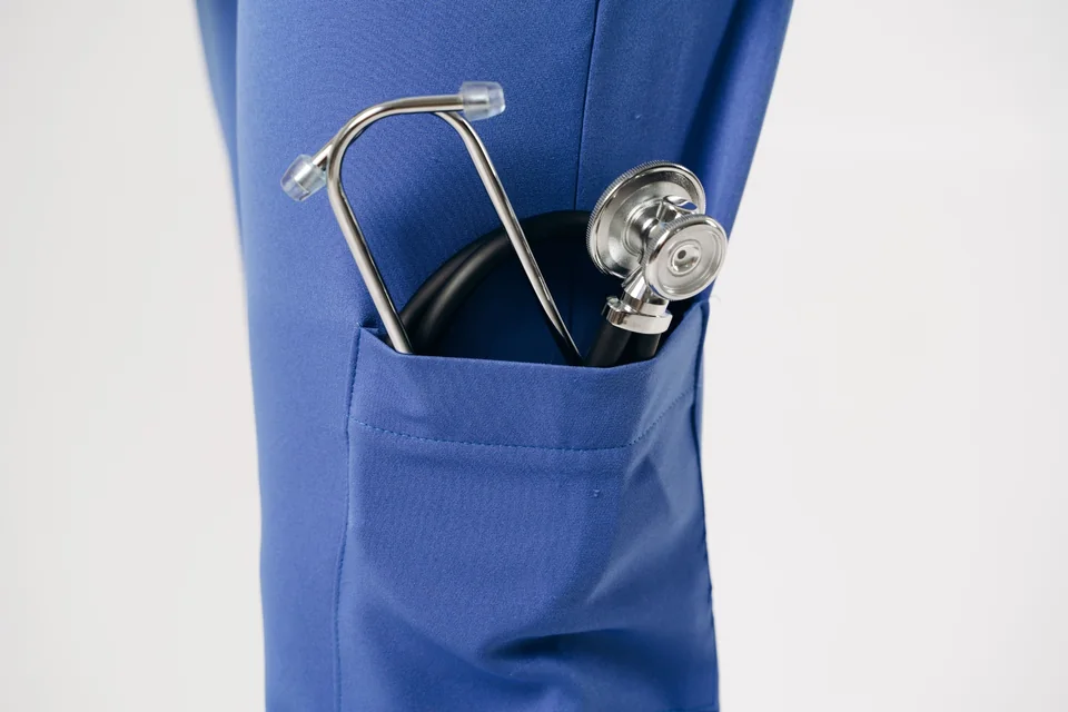 Stethoscope resting in a blue uniform pocket.