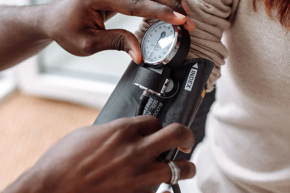 Healthcare professional checking a patient’s blood pressure.